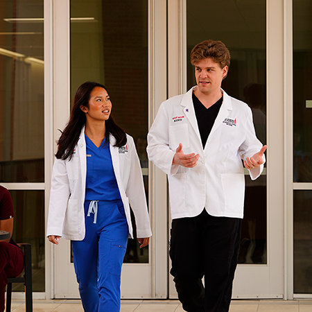 Two students in front of UIWSOM entrance